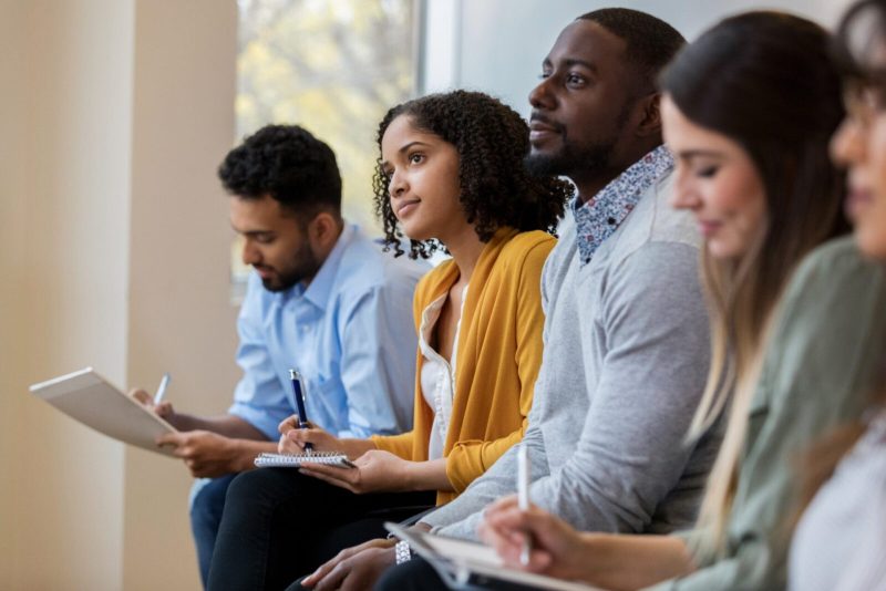 Group concentrating and taking notes during training or presentation